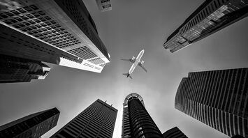 Airplane flying above city skyscrapers