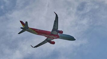 a red and white airplane flying in the sky