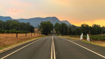 A long road leading towards mountains at sunset