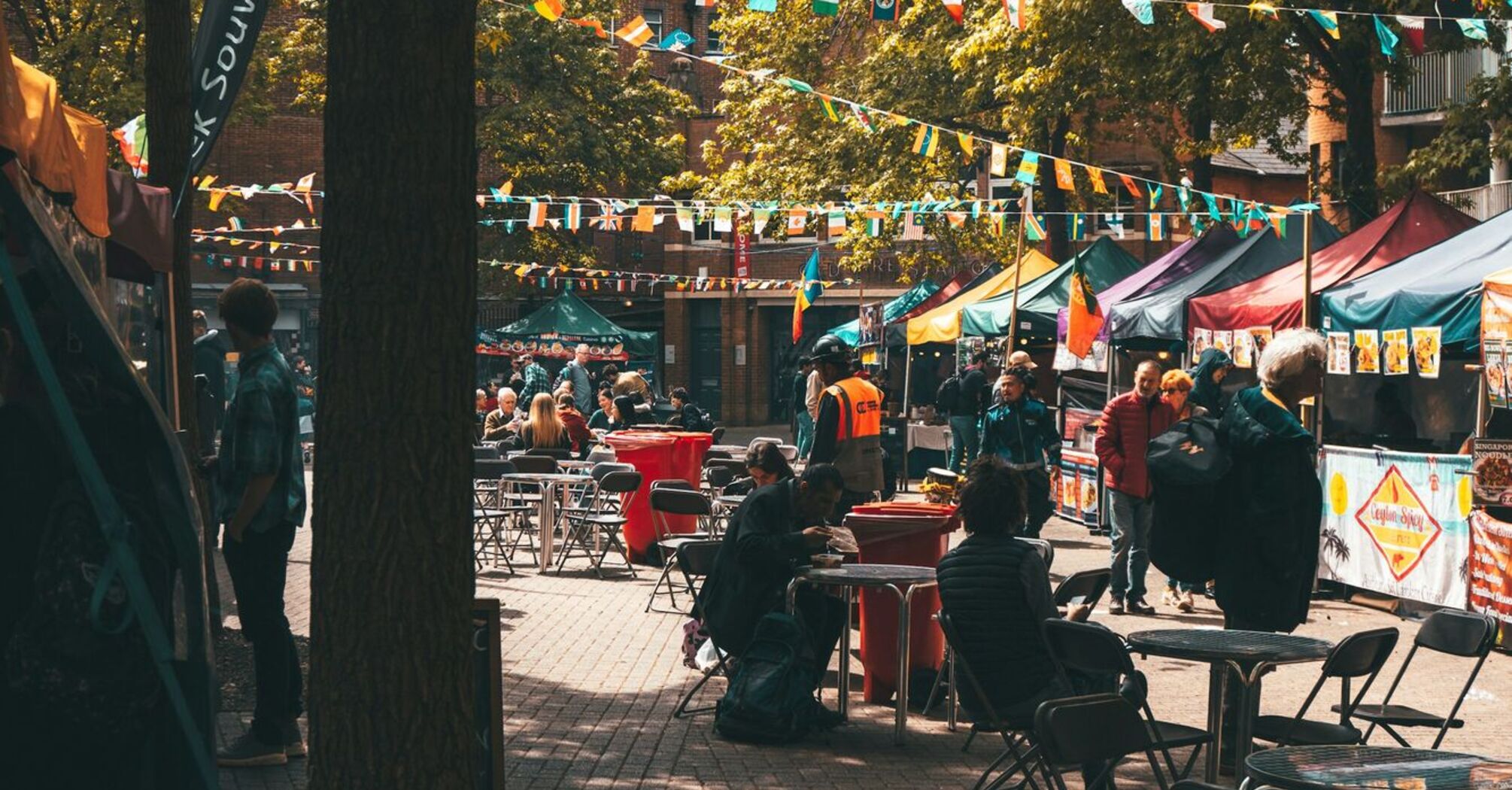 Food festival setup with flags and people sitting at tables