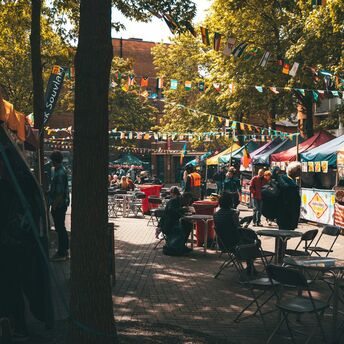 Food festival setup with flags and people sitting at tables