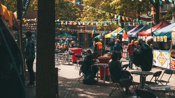 Food festival setup with flags and people sitting at tables