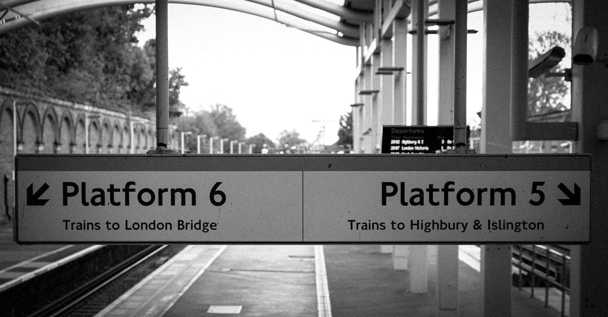 Train platform signs at a Crystal Palace railway station indicating directions to London Bridge and Highbury & Islington