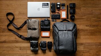 Travel and photography gear, including a backpack, camera, and accessories