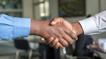 Two people shaking hands in a business setting