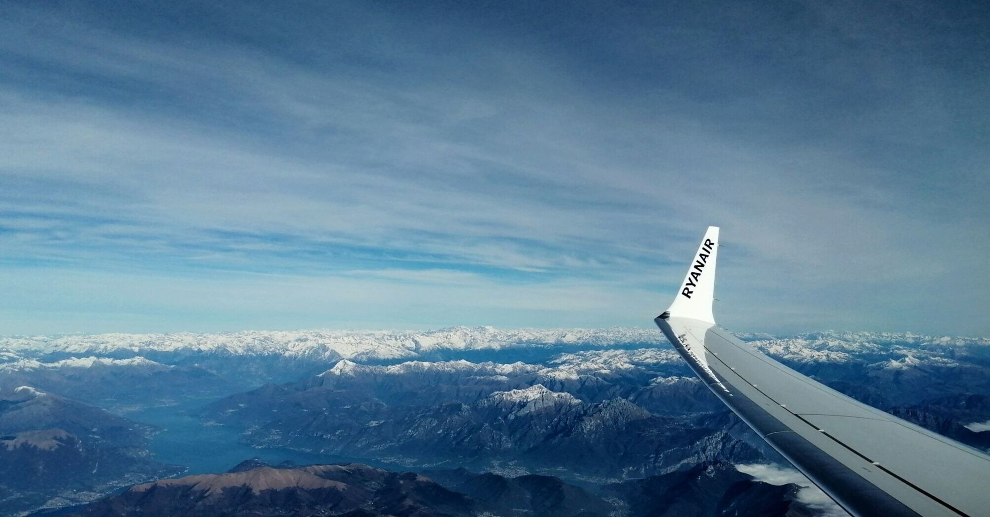 Ryanair wing flying over snowy mountains