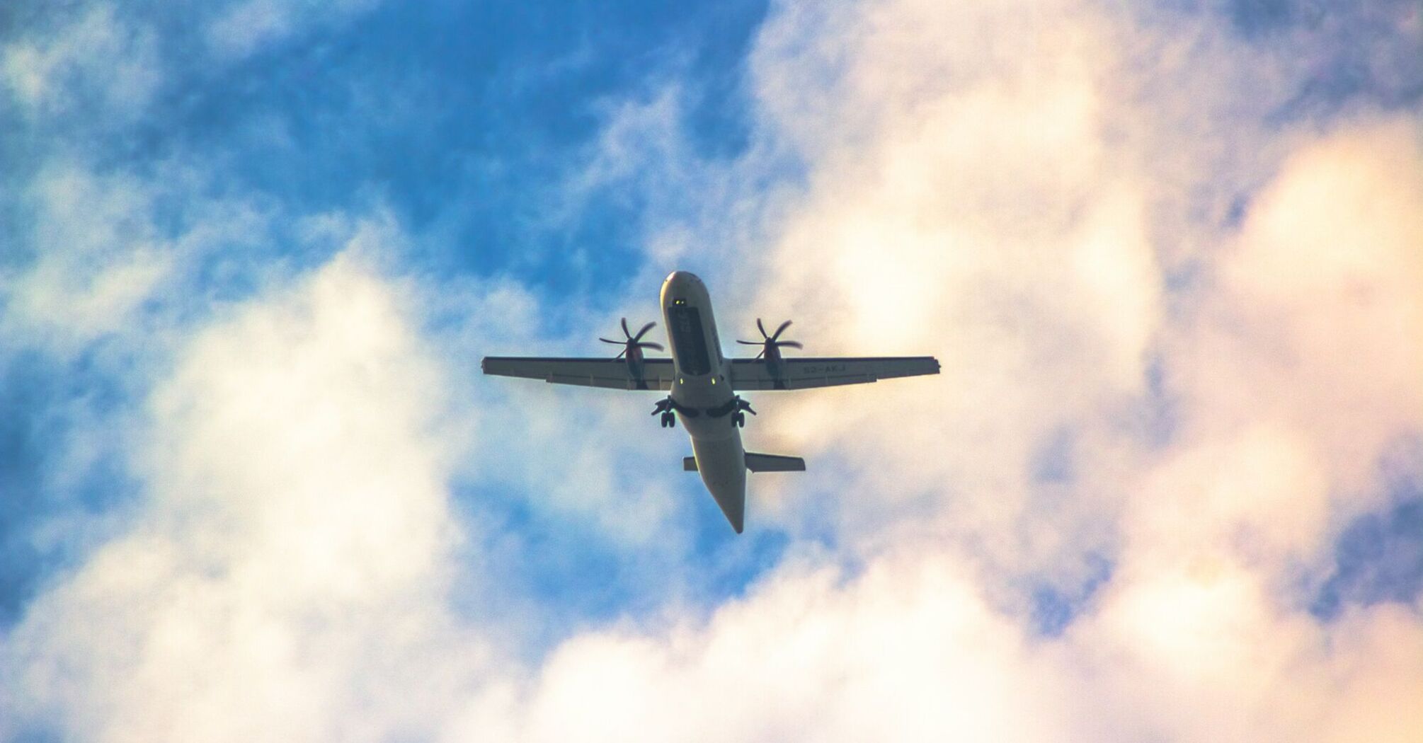 ATR-72 plane flying against a cloudy sky