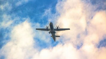 ATR-72 plane flying against a cloudy sky