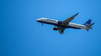 a large jetliner flying through a blue sky