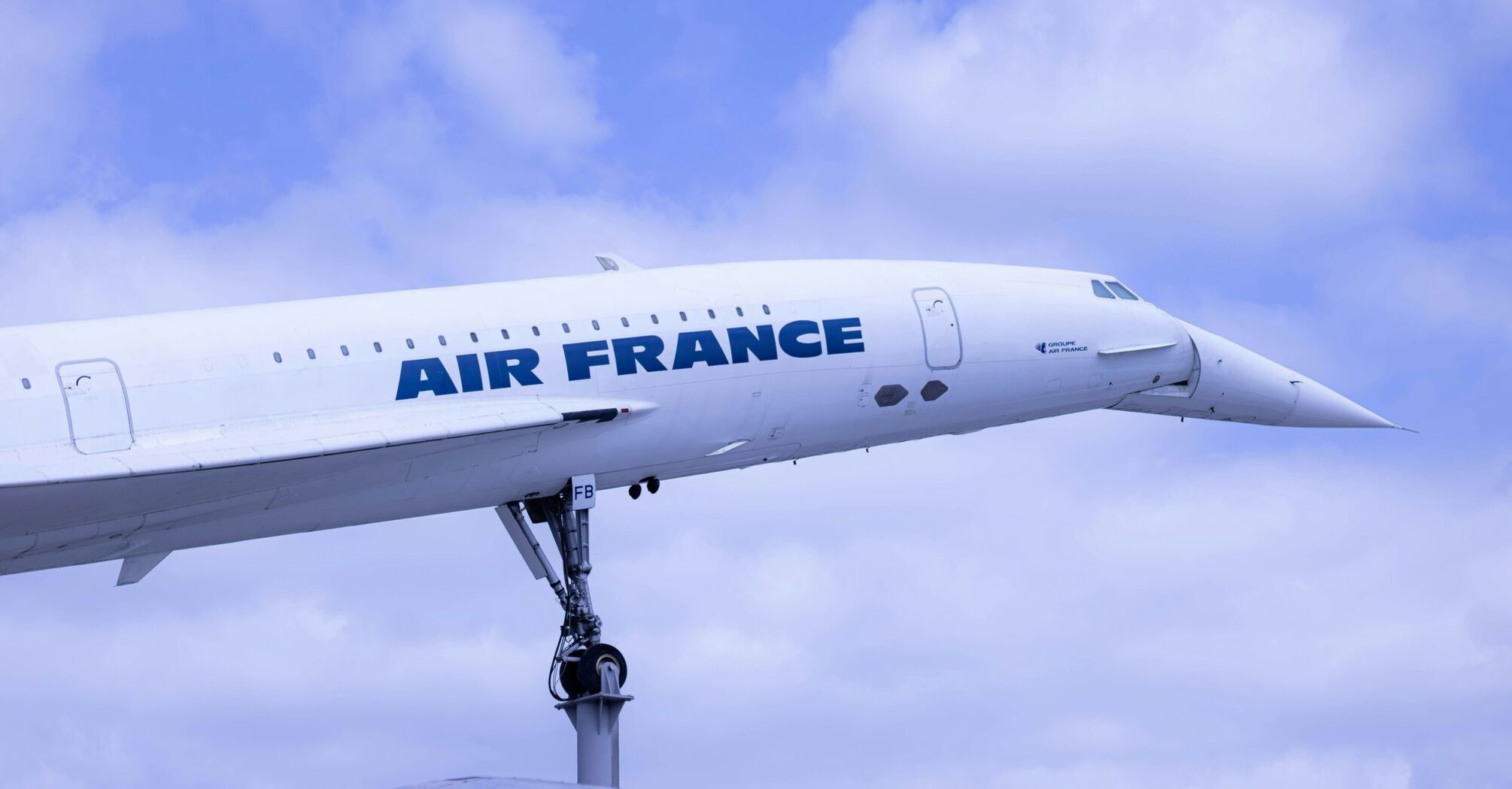 a large air france jetliner flying through a cloudy blue sky