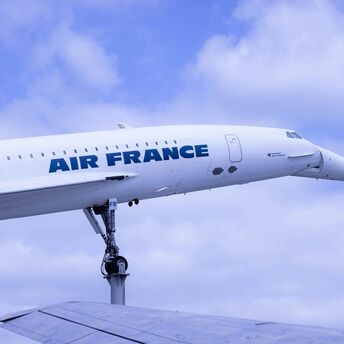 a large air france jetliner flying through a cloudy blue sky