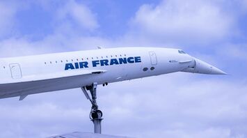 a large air france jetliner flying through a cloudy blue sky