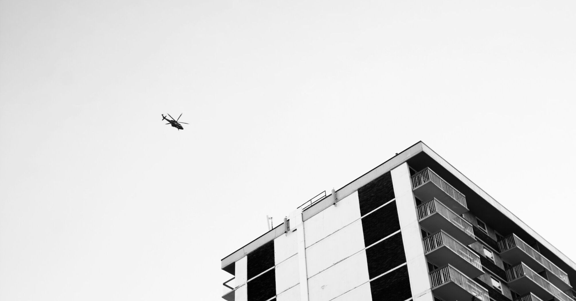 A helicopter flying above a high-rise building