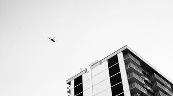 A helicopter flying above a high-rise building