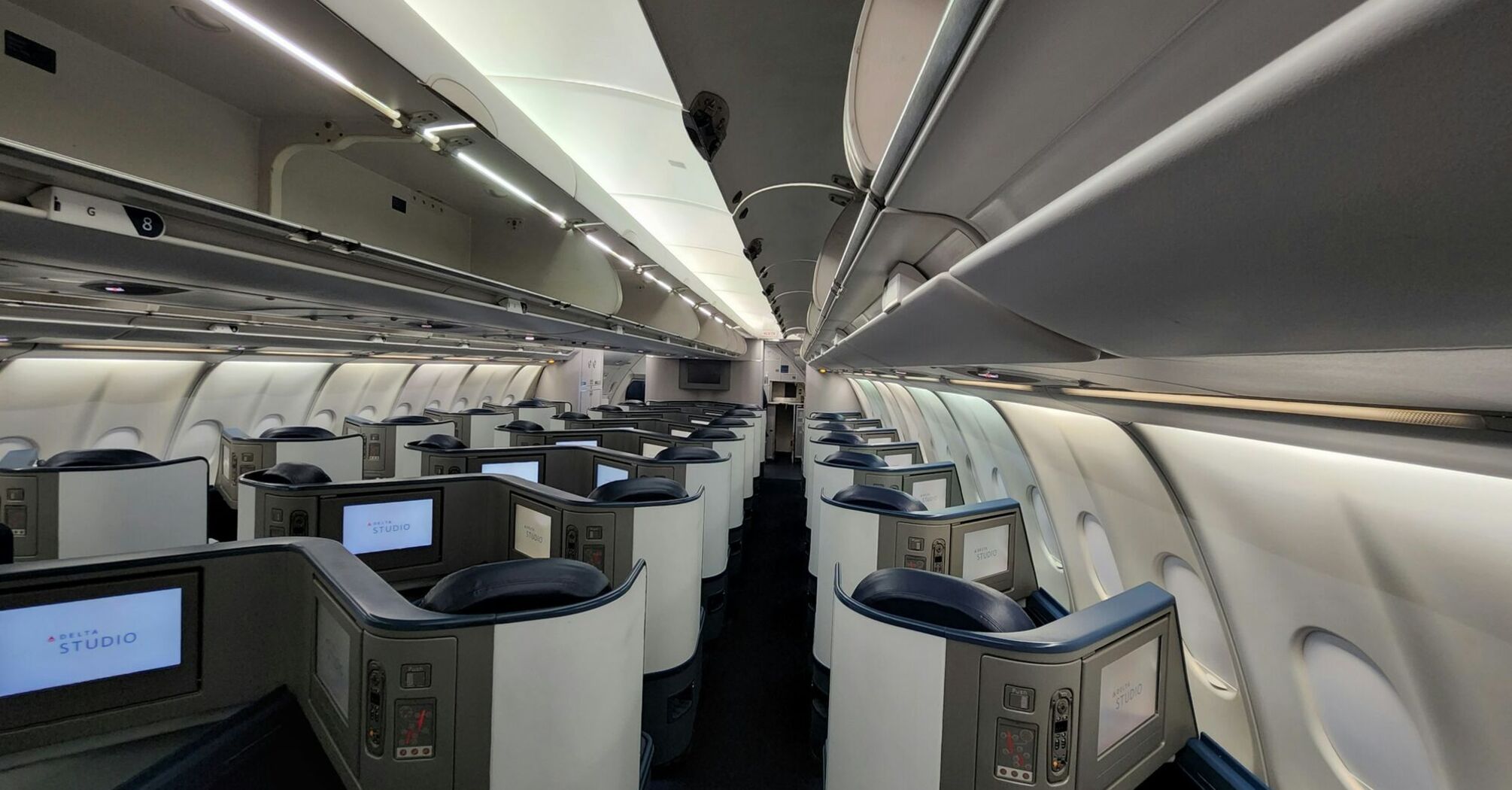 Delta Air Lines business class cabin with individual entertainment screens