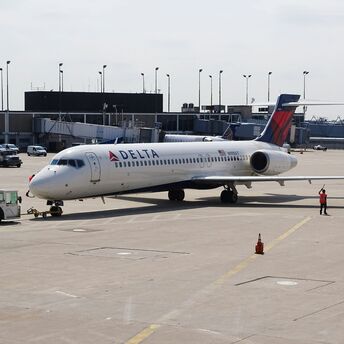 man standing beside white delta airplane