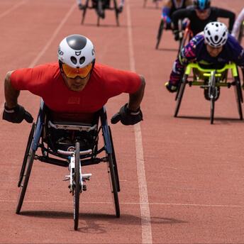 Athletes compete in a wheelchair race on the track