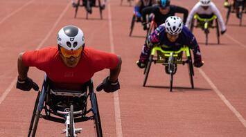 Athletes compete in a wheelchair race on the track