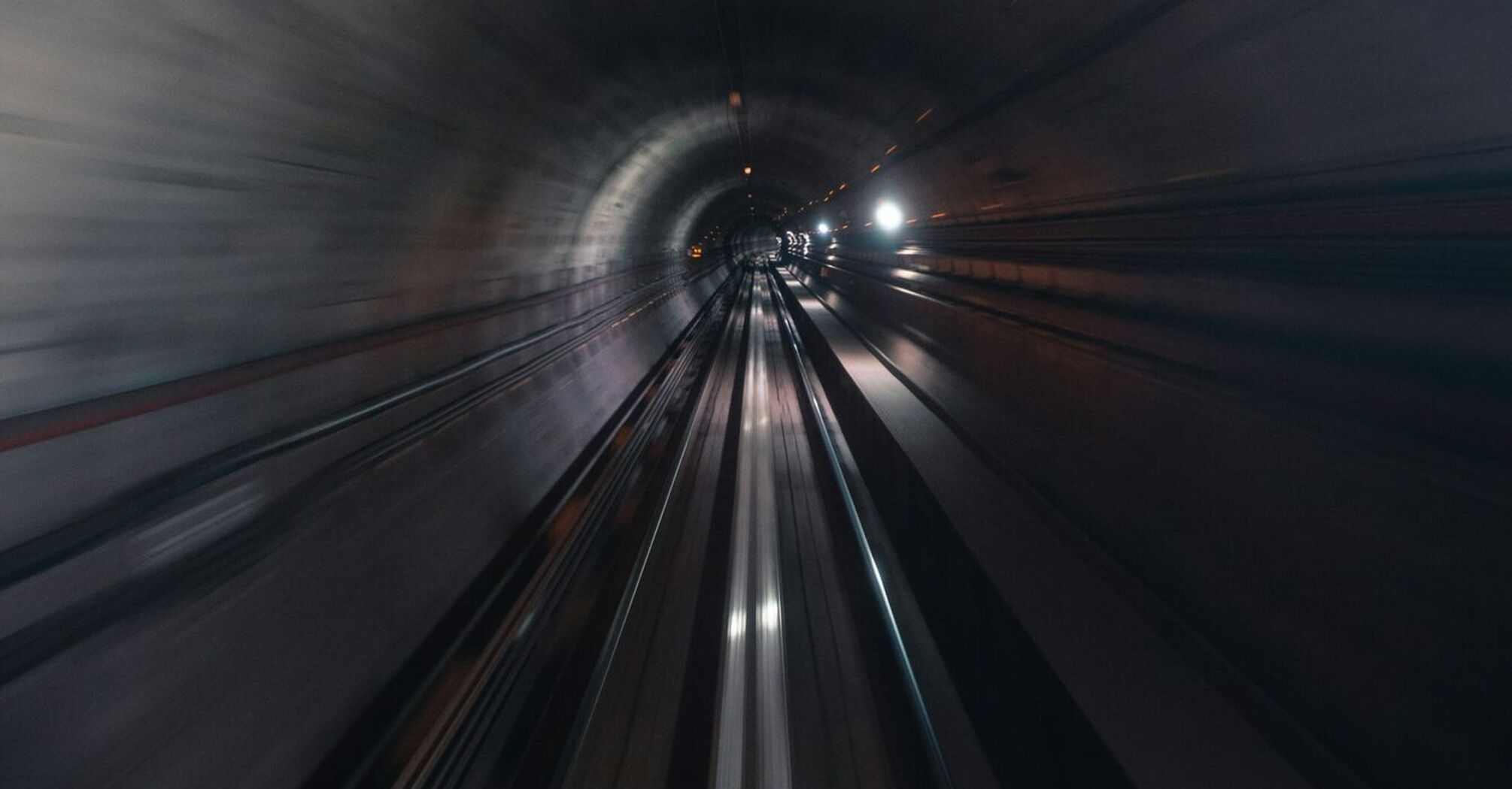 A high-speed view inside a dimly lit railway tunnel