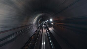 A high-speed view inside a dimly lit railway tunnel