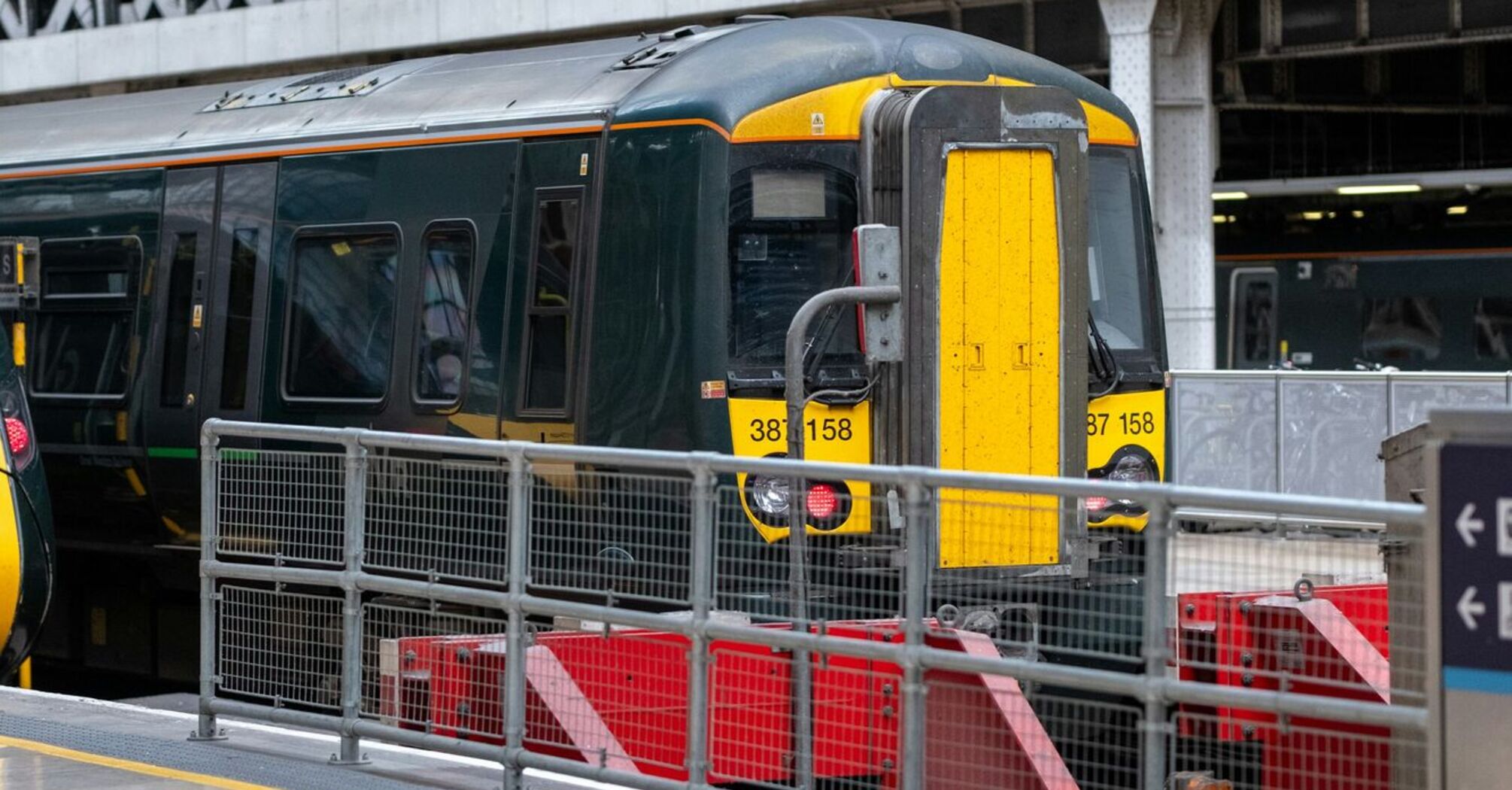 A stationary train at a platform inside a covered railway station