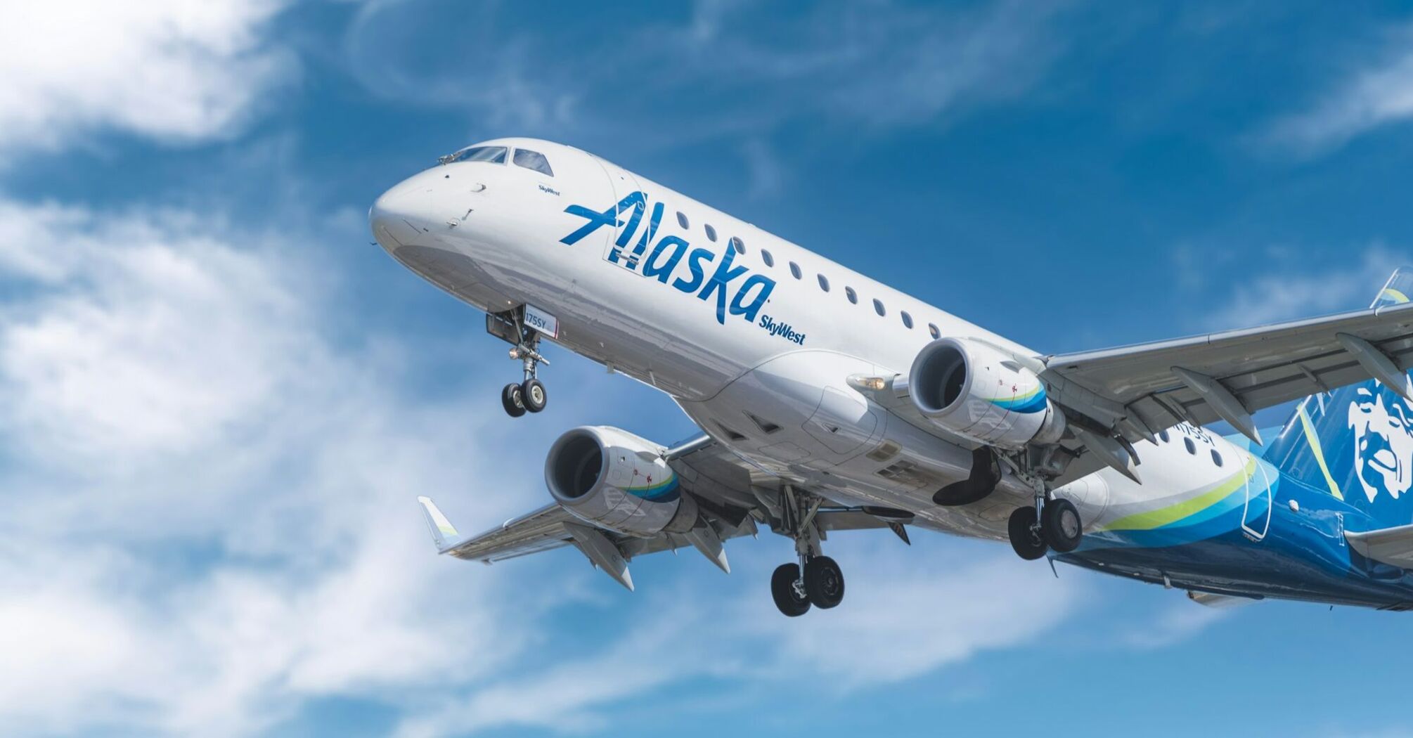 Alaska Airlines plane in flight against a blue sky