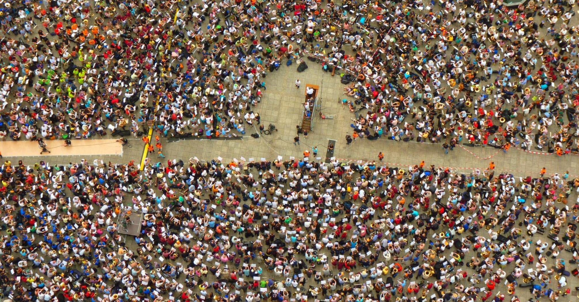 A large crowd of people gathered in a square for a public assembly or protest