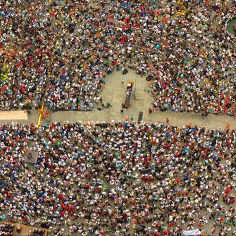 A large crowd of people gathered in a square for a public assembly or protest