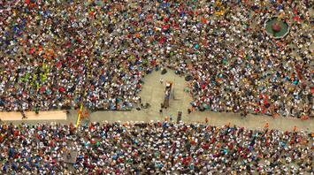 A large crowd of people gathered in a square for a public assembly or protest
