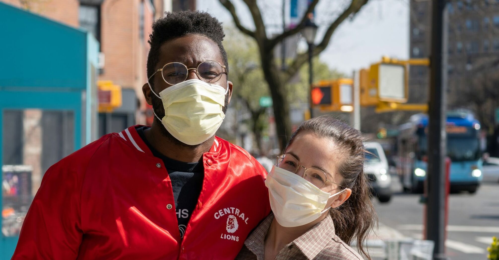 A man and woman wearing protective face masks outdoors