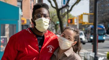 A man and woman wearing protective face masks outdoors