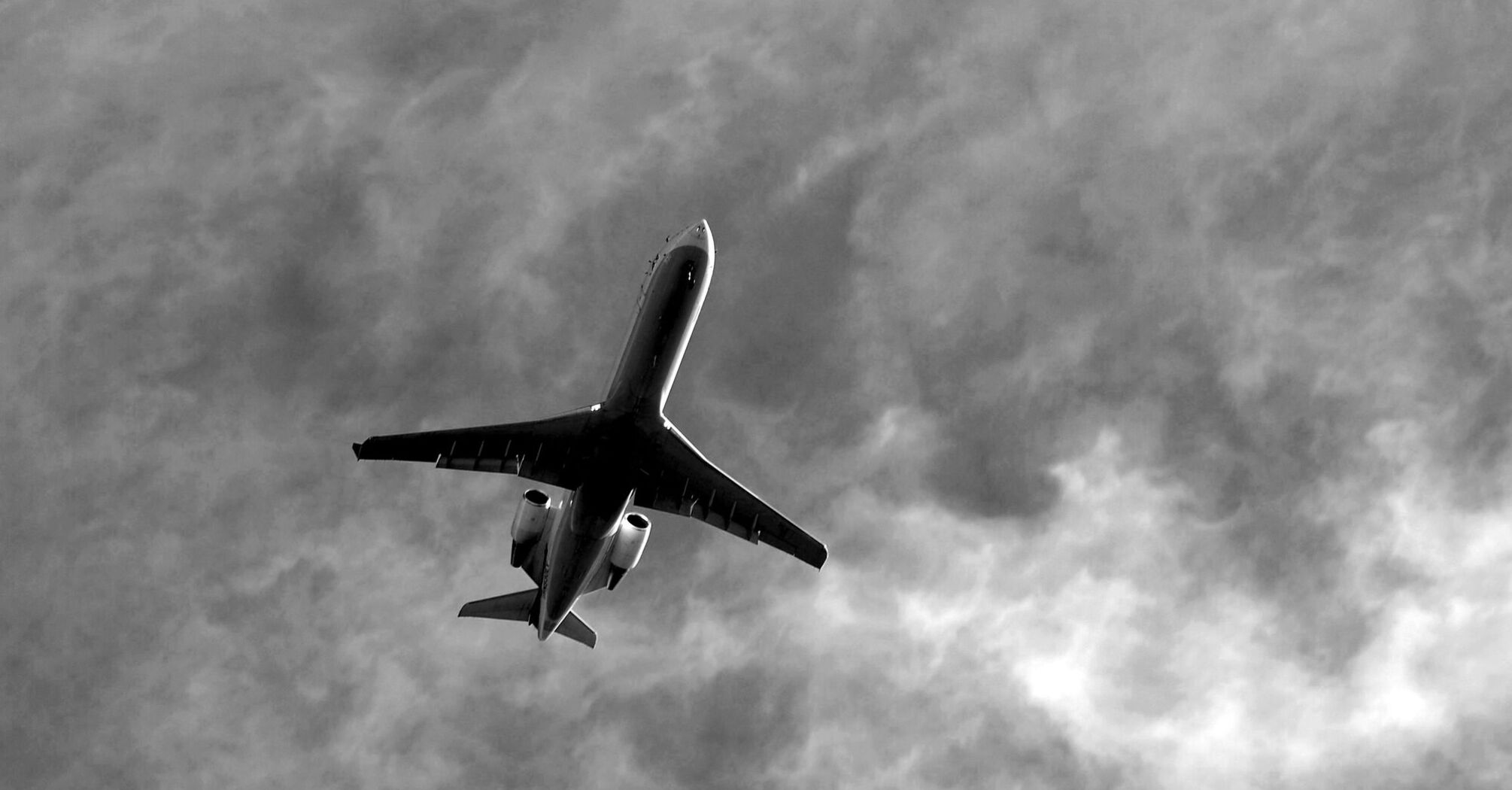 Commercial jetliner flying under cloudy skies