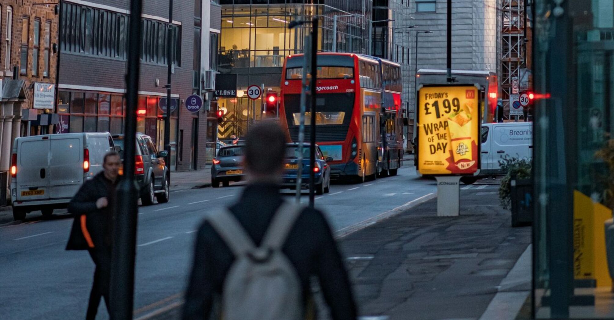 A busy street in Manchester with Stagecoach bus, pedestrians, and city buildings at dusk