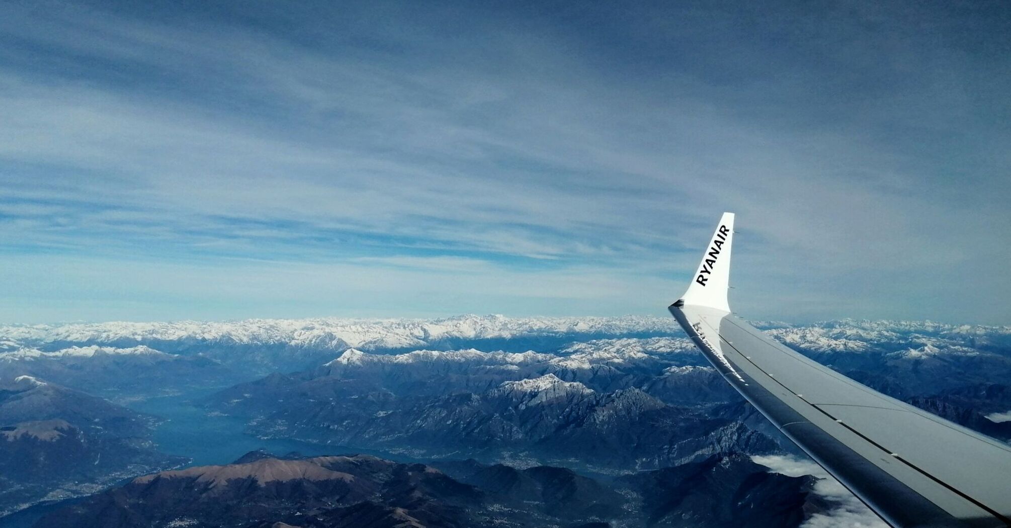 A Ryanair plane flying over snowy mountains