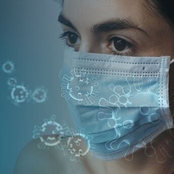 Woman wearing a mask surrounded by virus illustrations