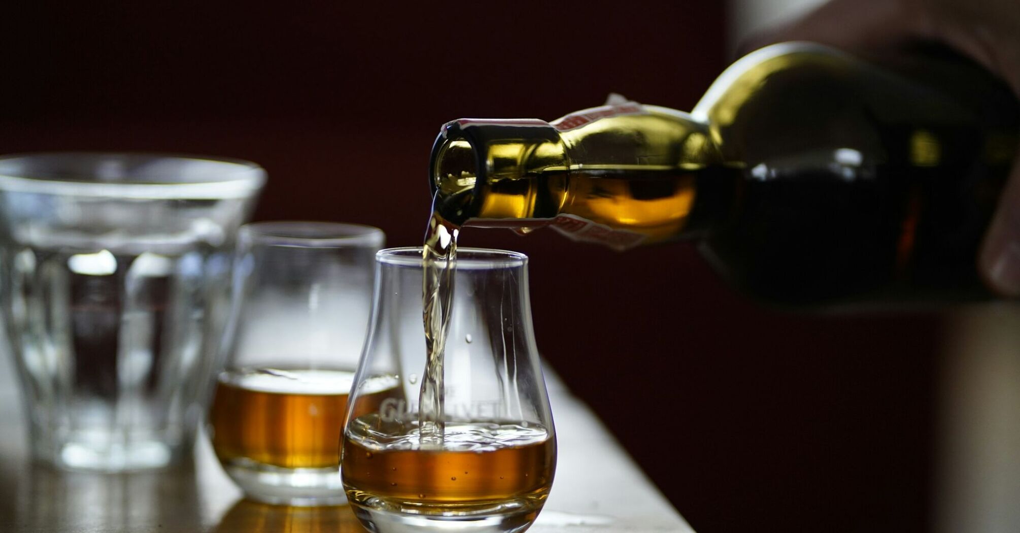 Whisky being poured into a glass, highlighting the golden color of the drink