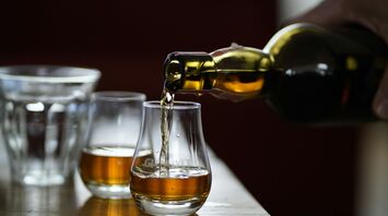 Whisky being poured into a glass, highlighting the golden color of the drink