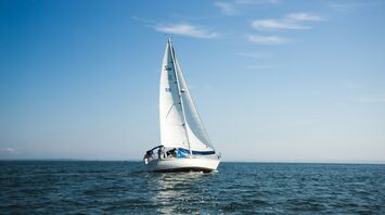 blue and white sailboat on ocean during daytime