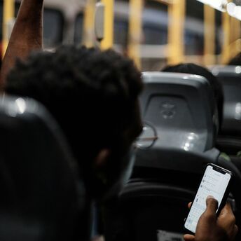 Passenger using a smartphone while riding on a bus