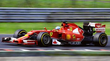 A red Formula One Ferrari racing car on the track