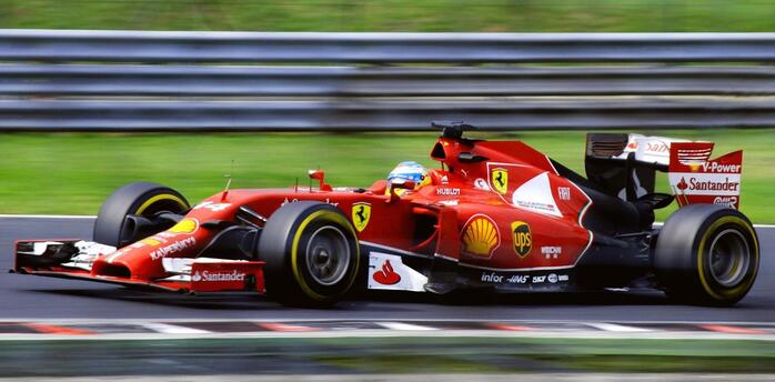 A red Formula One Ferrari racing car on the track