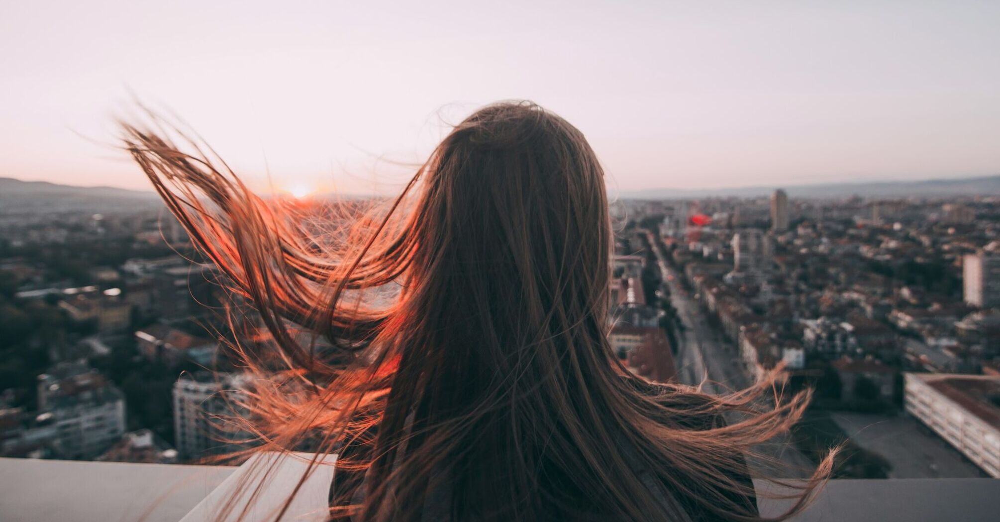 Woman overlooking Sofia cityscape at sunset