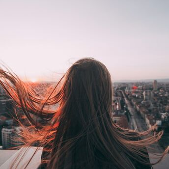 Woman overlooking Sofia cityscape at sunset