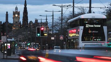A Lothian bus heading to Ocean Terminal on a busy Edinburgh street at dusk with historical buildings in the background