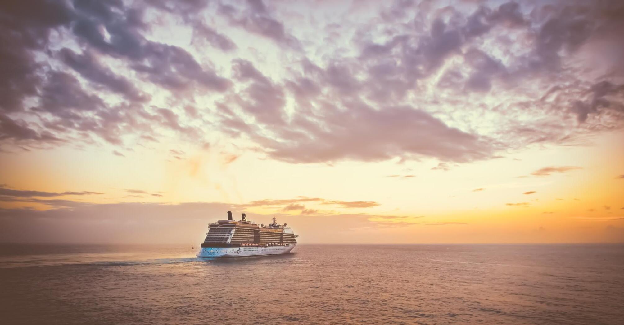 A cruise ship at sunset, sailing on the ocean