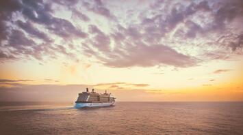 A cruise ship at sunset, sailing on the ocean