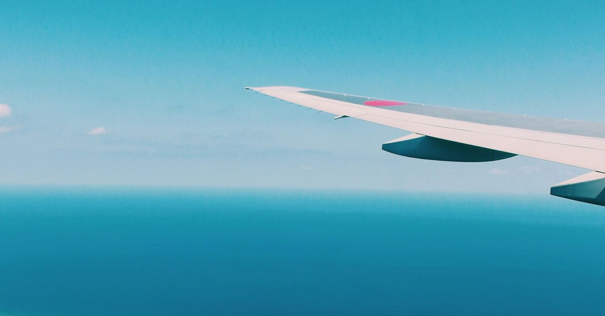 airplane wing over the ocean