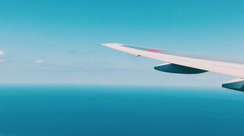 airplane wing over the ocean