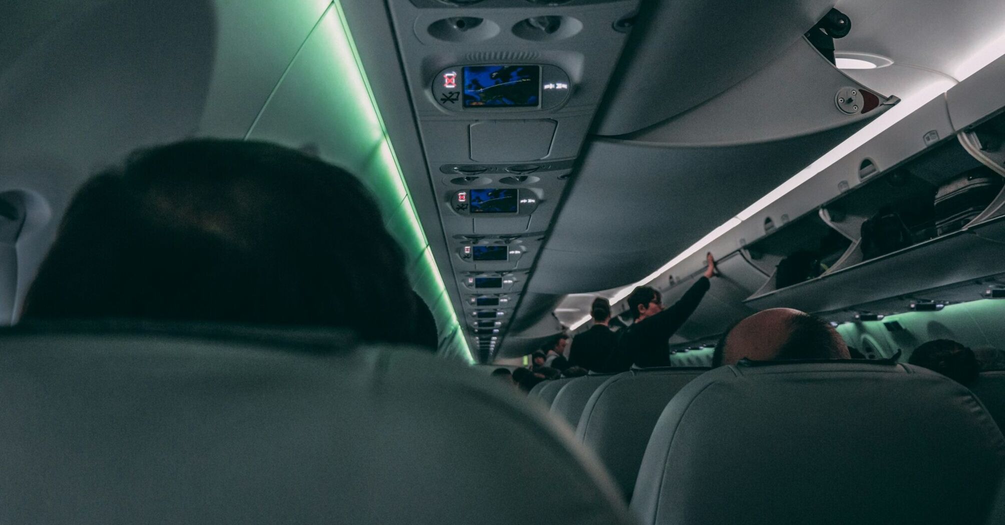 Interior of an airplane with passengers and overhead bins