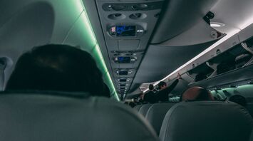 Interior of an airplane with passengers and overhead bins